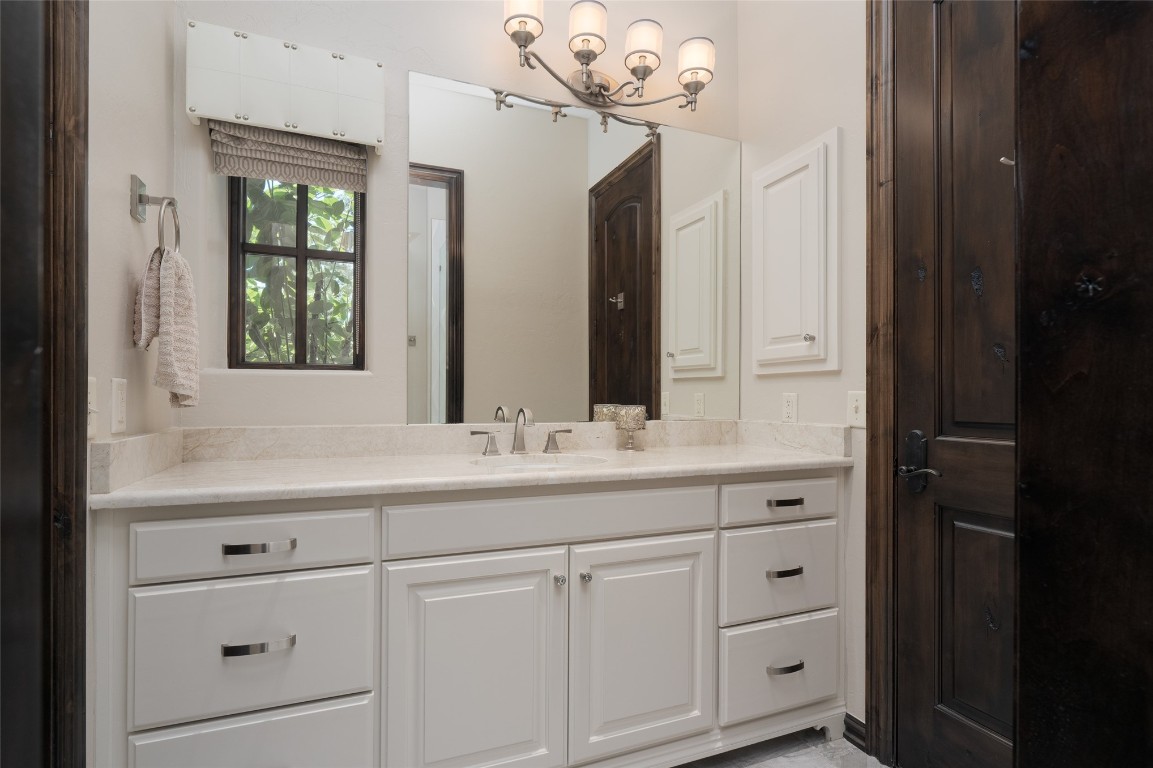 1200 Settlers Drive, Edmond, OK 73034 bathroom featuring vanity and an inviting chandelier