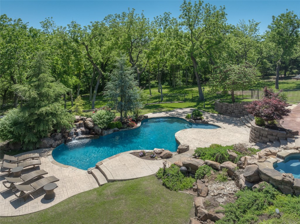 1200 Settlers Drive, Edmond, OK 73034 view of swimming pool featuring a hot tub, pool water feature, and a patio area
