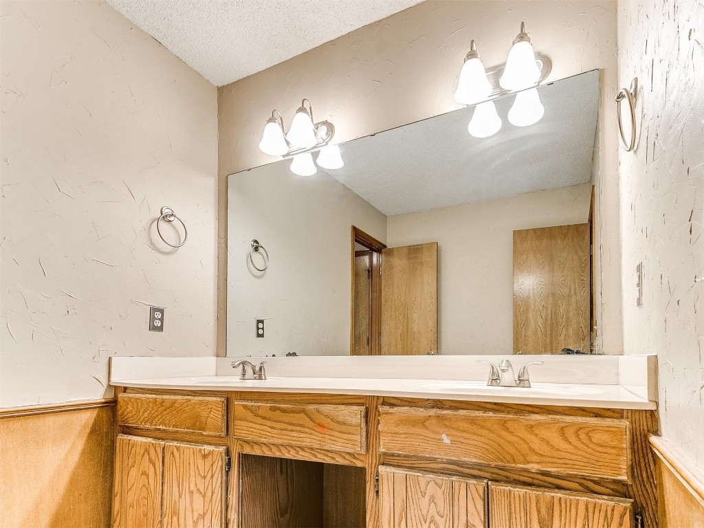 613 Cactus Court, Yukon, OK 73099 bathroom with a textured ceiling and double sink vanity