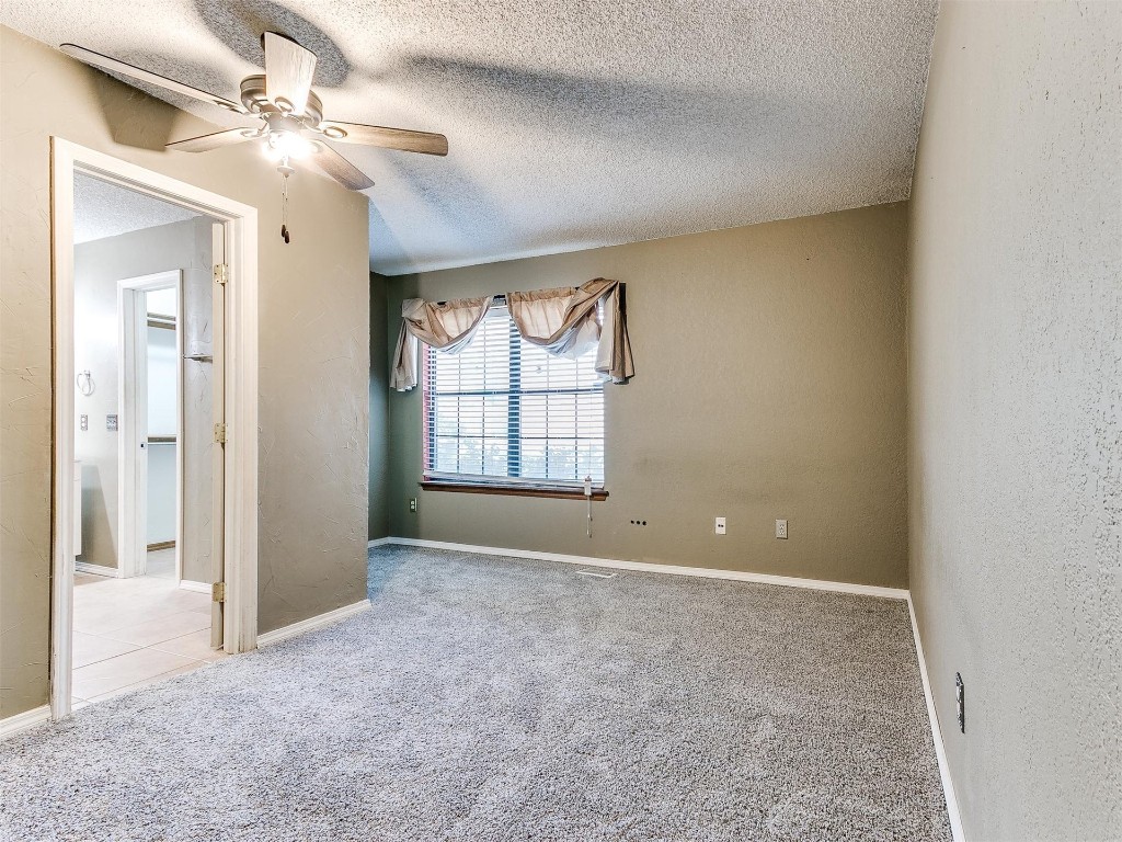 613 Cactus Court, Yukon, OK 73099 unfurnished bedroom featuring ceiling fan, carpet flooring, and a textured ceiling