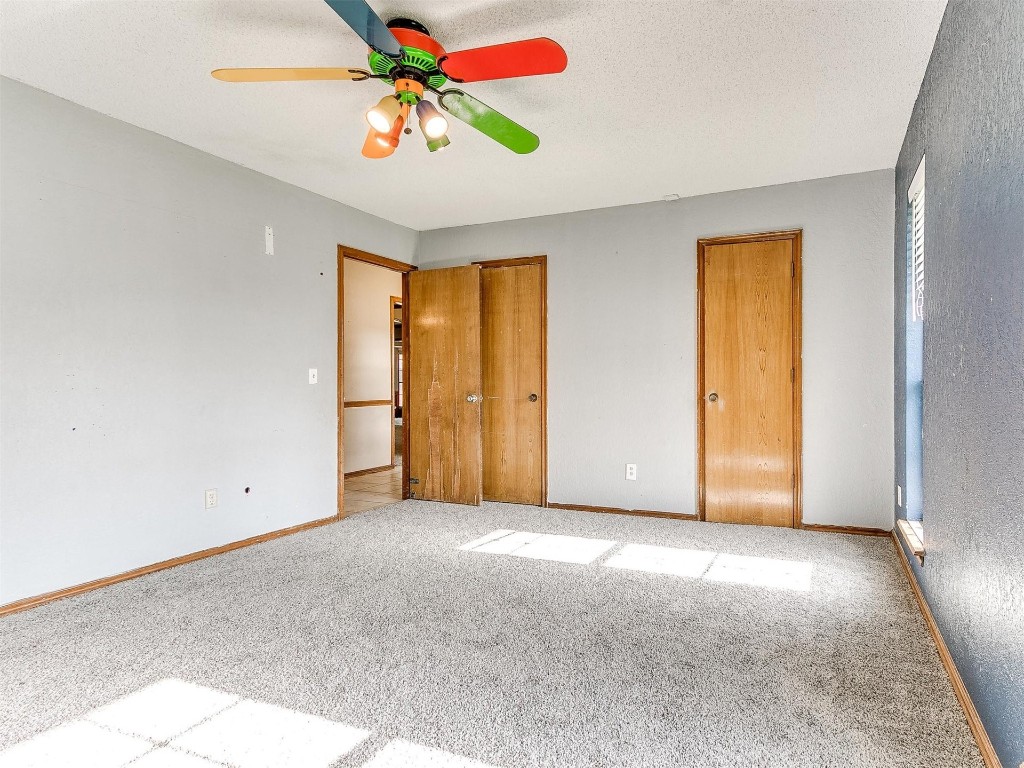 613 Cactus Court, Yukon, OK 73099 unfurnished bedroom featuring a closet, ceiling fan, and carpet floors