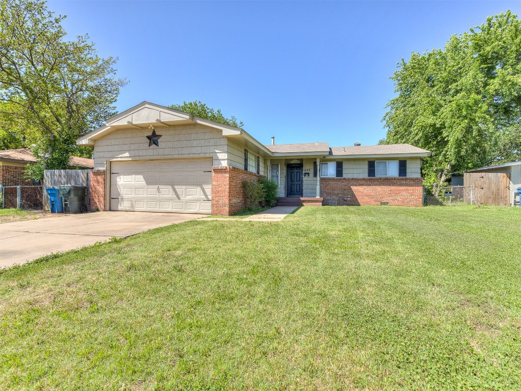 427 W Fairchild Drive, Midwest City, OK 73110 single story home featuring a garage and a front lawn