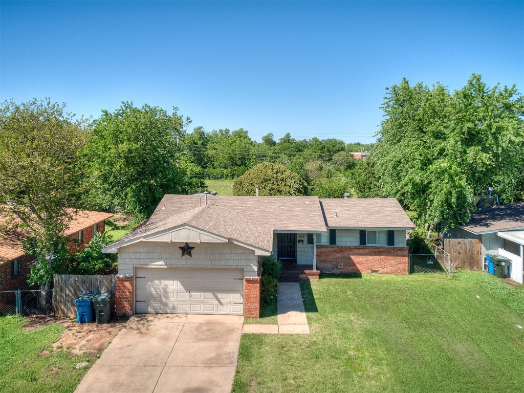 427 W Fairchild Drive, Midwest City, OK 73110 ranch-style home with a garage and a front yard