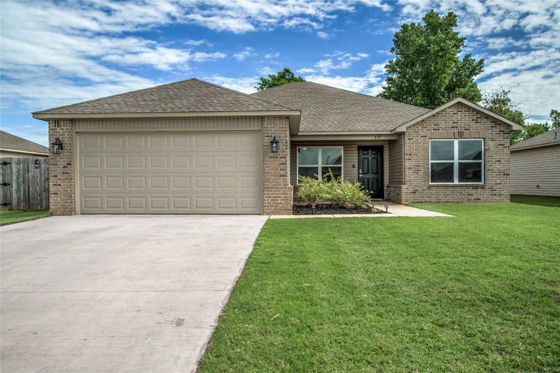 633 W Ava Drive, Mustang, OK 73064 single story home with a garage and a front lawn