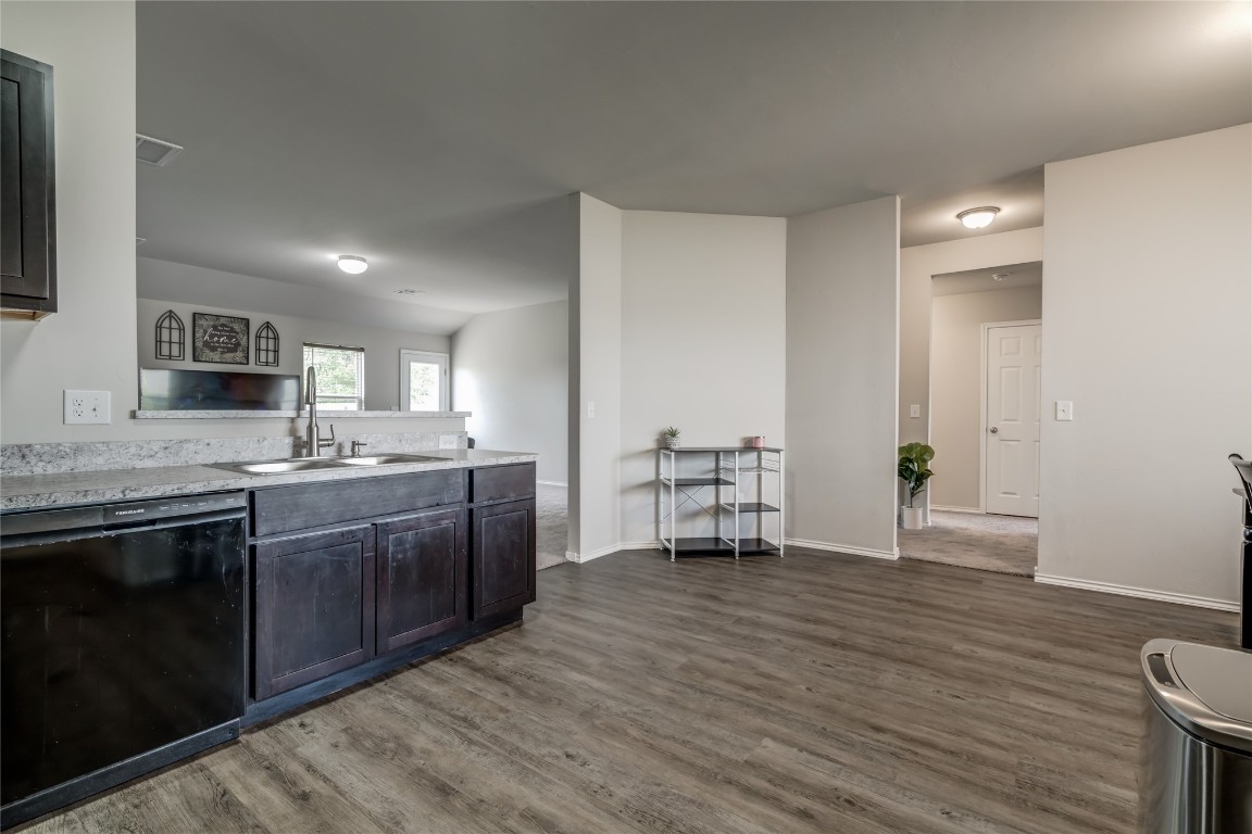 633 W Ava Drive, Mustang, OK 73064 kitchen featuring sink, dark wood-type flooring, and black dishwasher