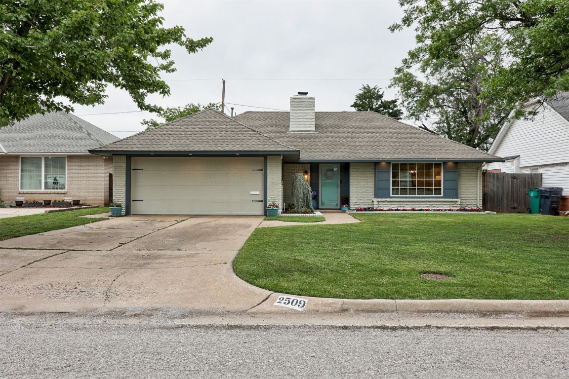 2509 NW 58th Street, Oklahoma City, OK 73112 single story home featuring a front lawn and a garage