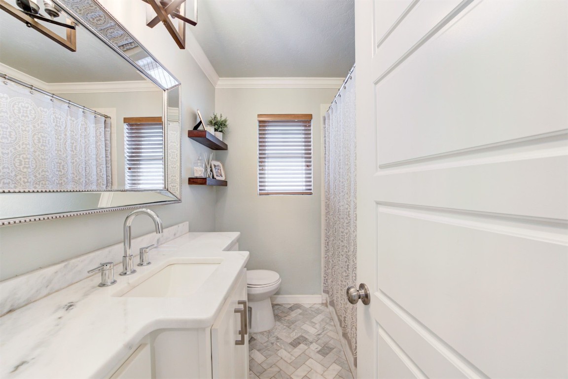 2509 NW 58th Street, Oklahoma City, OK 73112 bathroom with ornamental molding, tile flooring, vanity, and toilet