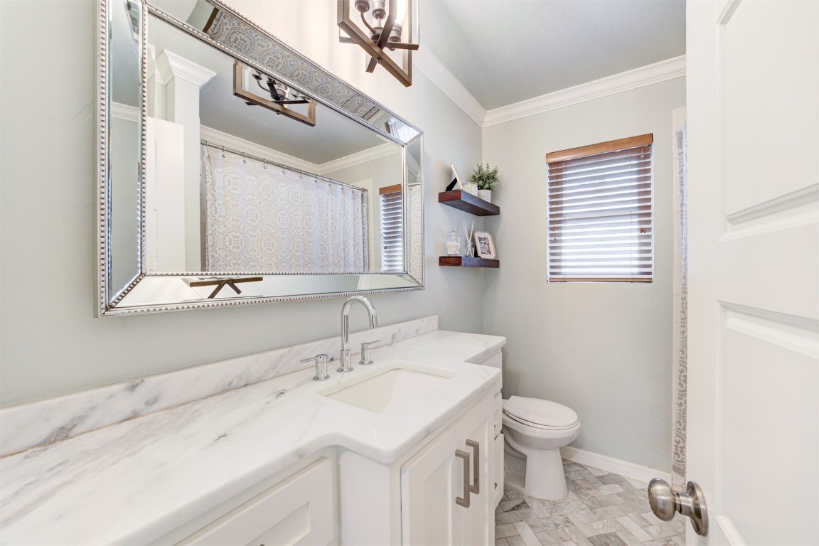 2509 NW 58th Street, Oklahoma City, OK 73112 bathroom featuring ornamental molding, toilet, tile floors, and vanity