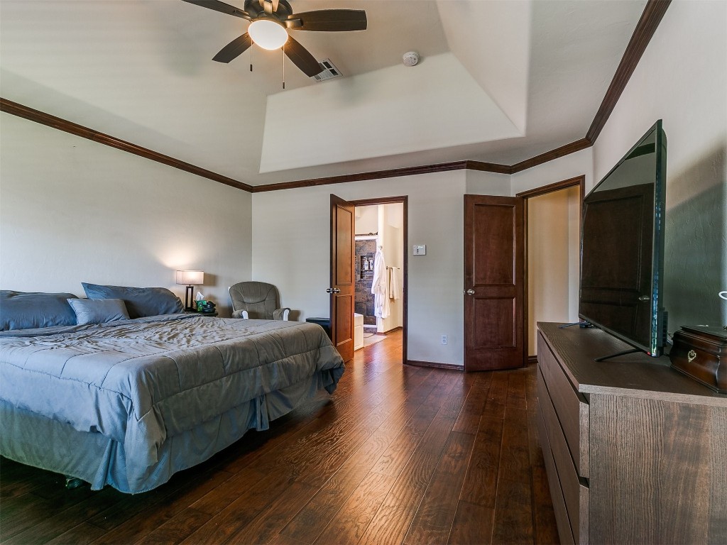 17001 Kemble Lane, Edmond, OK 73012 bedroom featuring dark hardwood / wood-style flooring, ceiling fan, and a raised ceiling