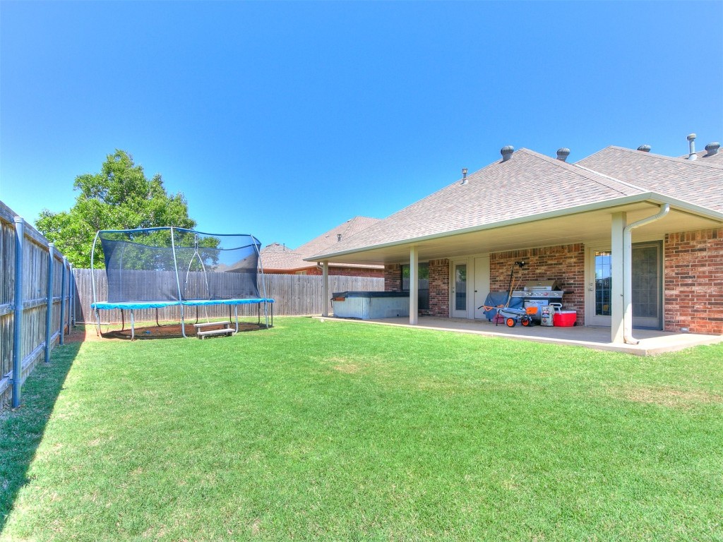 17001 Kemble Lane, Edmond, OK 73012 view of yard with a trampoline and a patio area