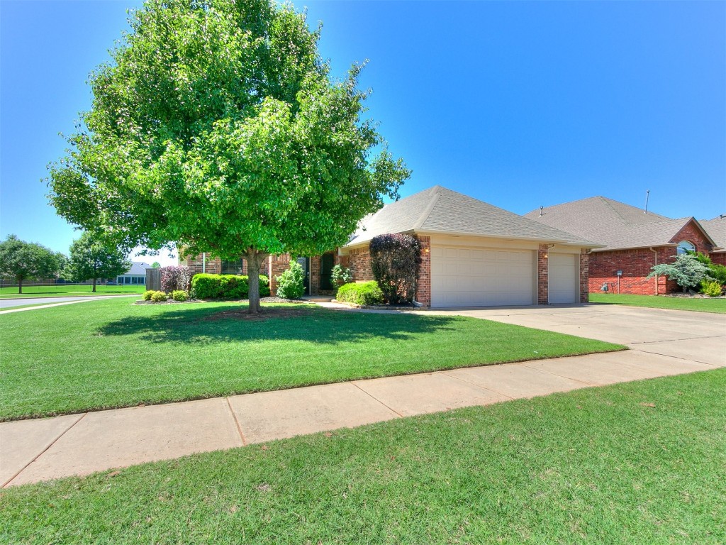 17001 Kemble Lane, Edmond, OK 73012 view of front of property featuring a garage and a front lawn
