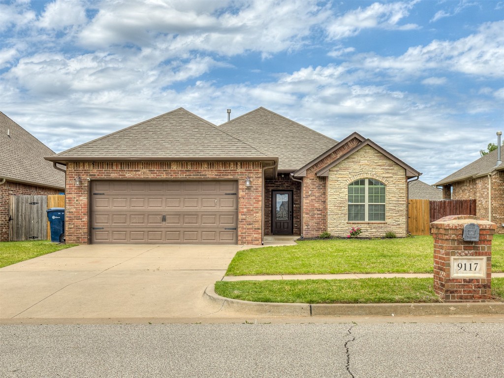 9117 NW 139th Street, Yukon, OK 73099 ranch-style home with a garage and a front yard