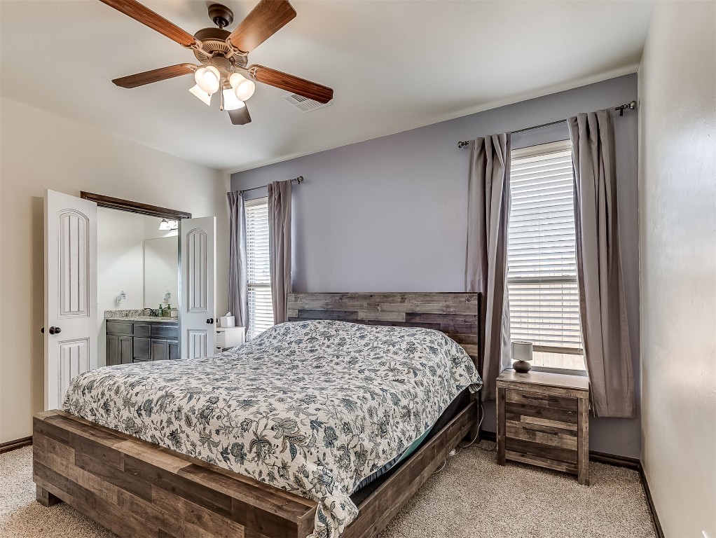 9117 NW 139th Street, Yukon, OK 73099 bedroom featuring light colored carpet, multiple windows, and ceiling fan