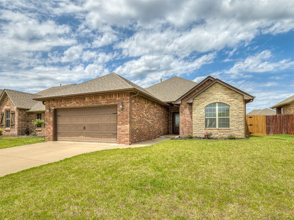 9117 NW 139th Street, Yukon, OK 73099 ranch-style home with a garage and a front lawn