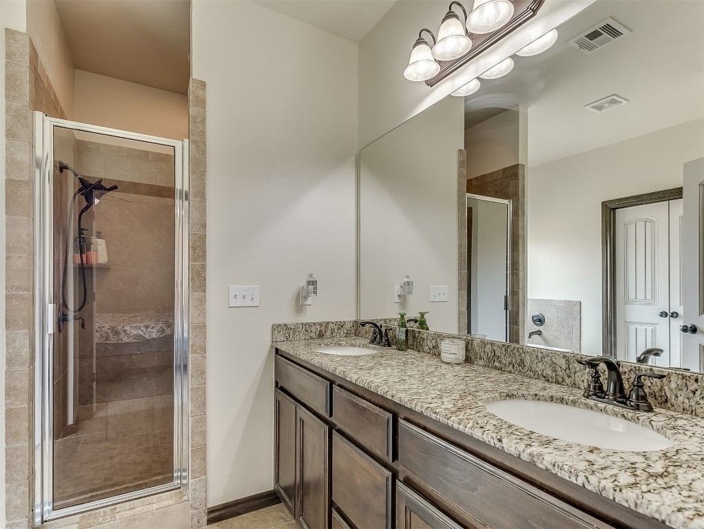 9117 NW 139th Street, Yukon, OK 73099 bathroom with double sink, a shower with shower door, and oversized vanity