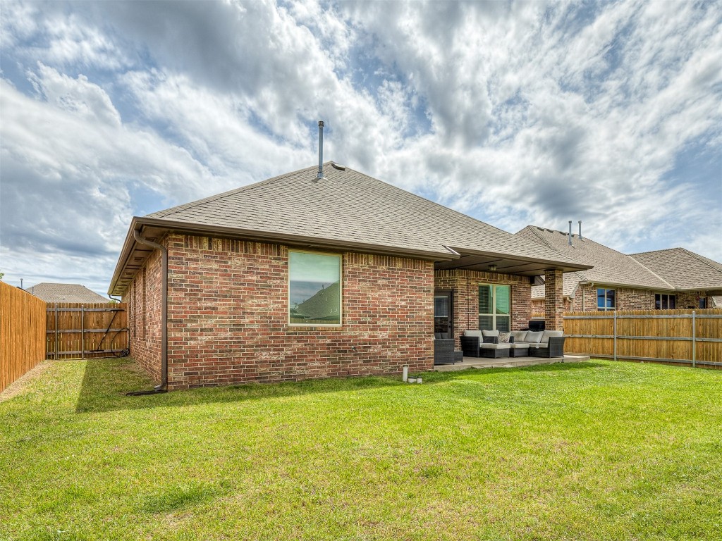 9117 NW 139th Street, Yukon, OK 73099 rear view of property featuring a patio, a yard, and an outdoor hangout area