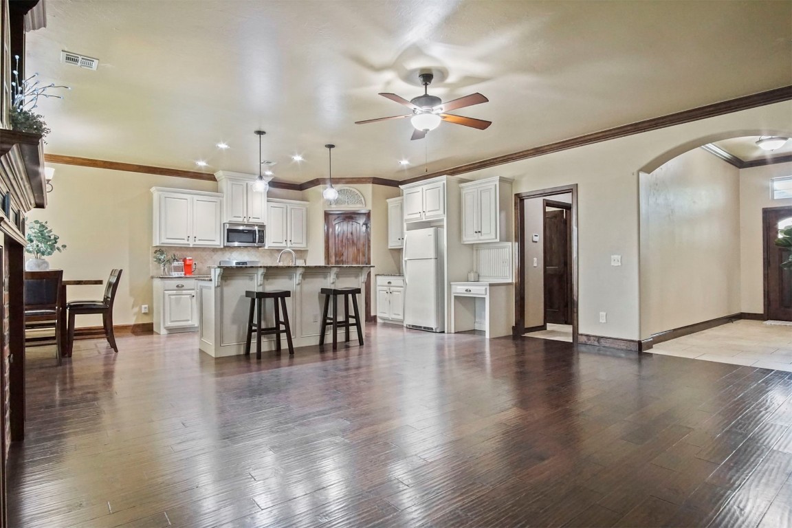 3405 NW 164th Street, Edmond, OK 73013 living room featuring dark hardwood / wood-style floors, ceiling fan, and ornamental molding