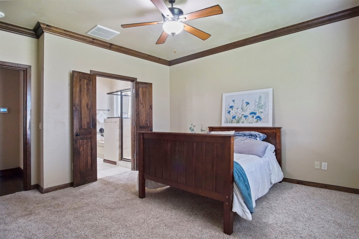 3405 NW 164th Street, Edmond, OK 73013 carpeted bedroom with ceiling fan and ornamental molding