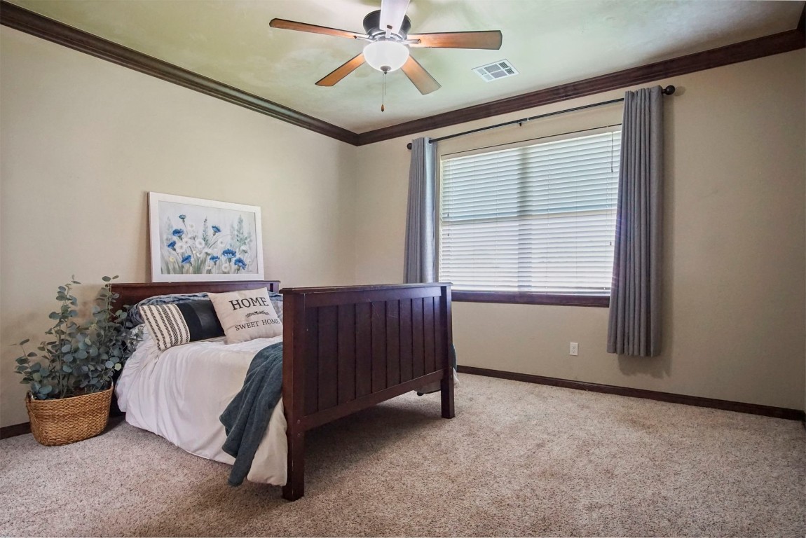 3405 NW 164th Street, Edmond, OK 73013 carpeted bedroom with crown molding and ceiling fan