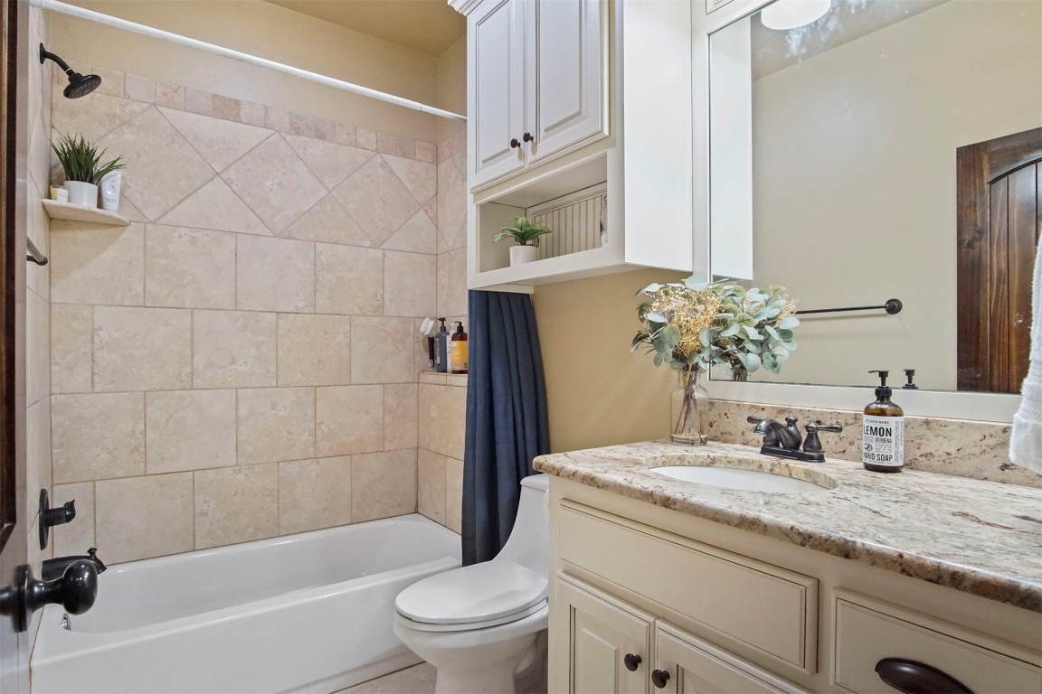3405 NW 164th Street, Edmond, OK 73013 full bathroom featuring tiled shower / bath, toilet, and large vanity