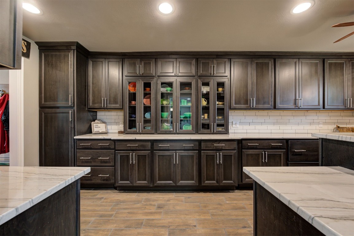 10315 E Post Oak Road, Noble, OK 73068 kitchen featuring tasteful backsplash, light stone countertops, ceiling fan, and dark brown cabinetry