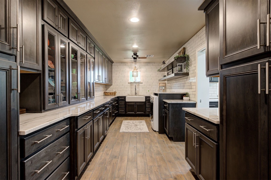 10315 E Post Oak Road, Noble, OK 73068 kitchen featuring paneled fridge, ceiling fan, light hardwood / wood-style floors, tasteful backsplash, and light stone counters