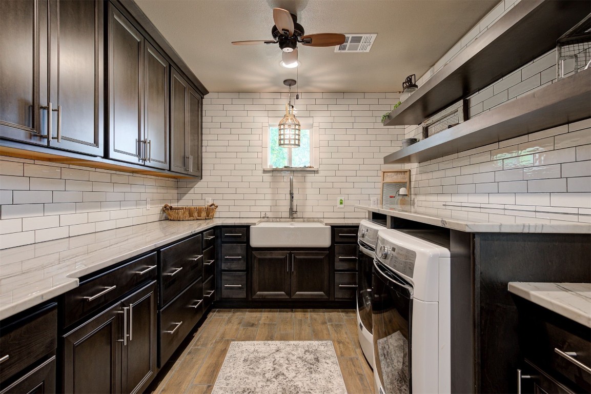 10315 E Post Oak Road, Noble, OK 73068 kitchen featuring sink, backsplash, light wood-type flooring, and washer / dryer