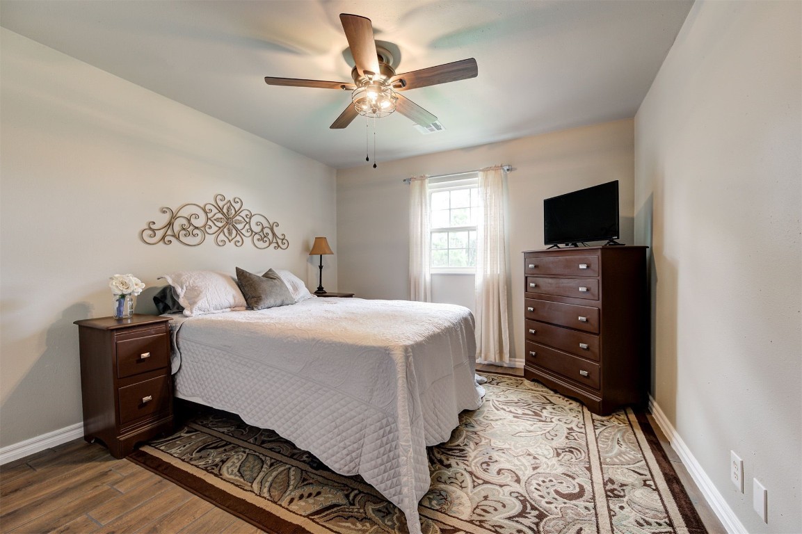 10315 E Post Oak Road, Noble, OK 73068 bedroom with ceiling fan and hardwood / wood-style floors