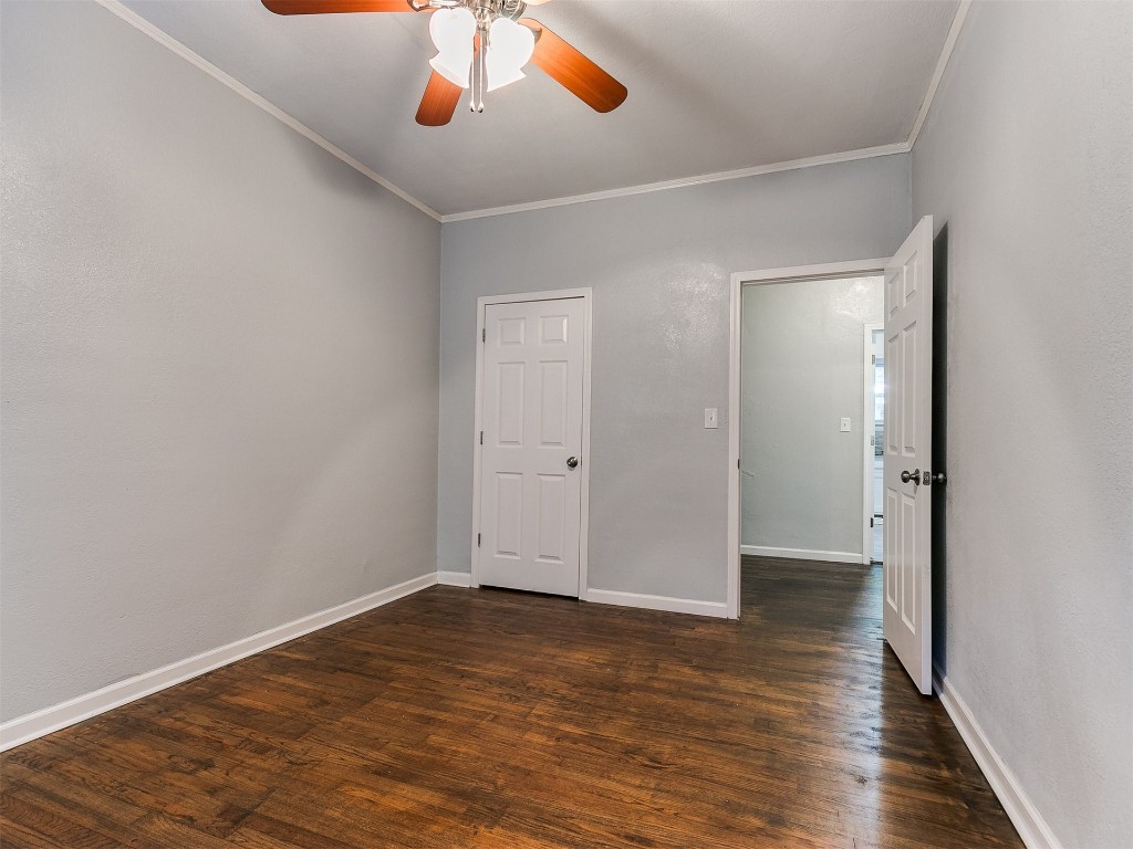 2224 N Indiana Avenue, Oklahoma City, OK 73106 unfurnished bedroom with dark hardwood / wood-style floors, ceiling fan, and ornamental molding
