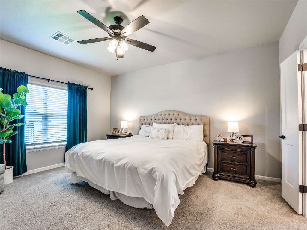 18725 Big Cedar Way, Edmond, OK 73012 bedroom featuring light carpet and ceiling fan