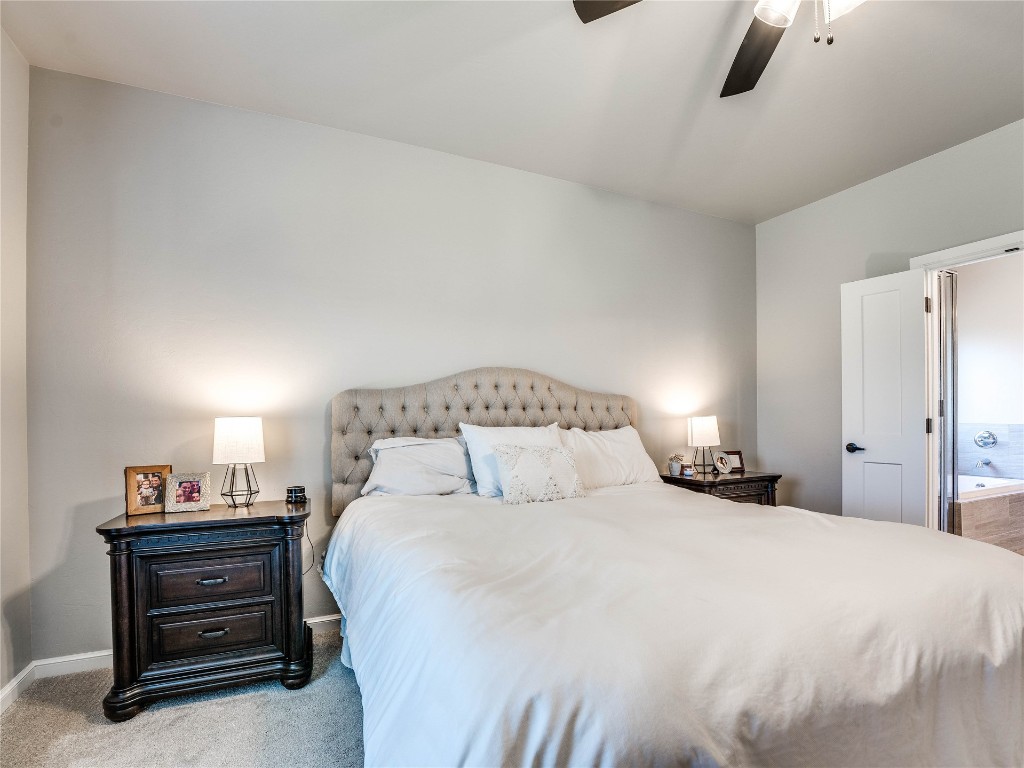 18725 Big Cedar Way, Edmond, OK 73012 carpeted bedroom featuring connected bathroom and ceiling fan