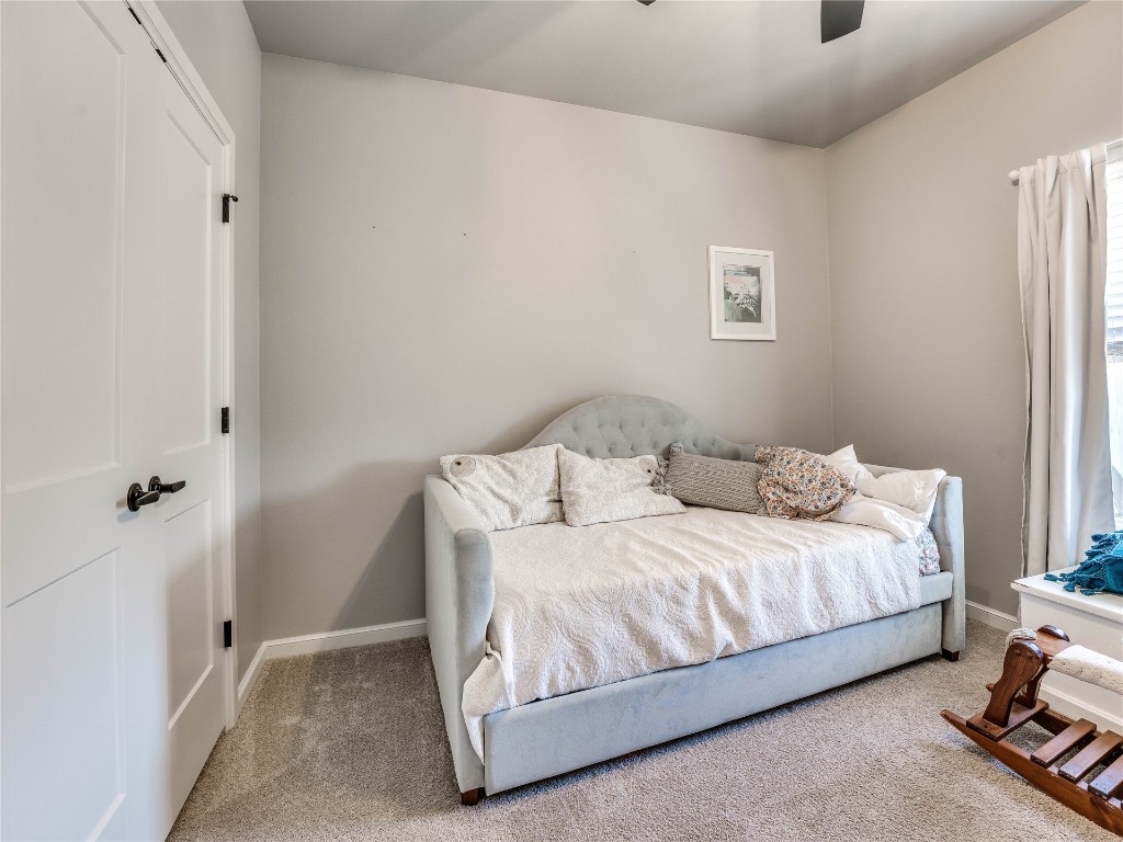 18725 Big Cedar Way, Edmond, OK 73012 bedroom with light colored carpet and ceiling fan