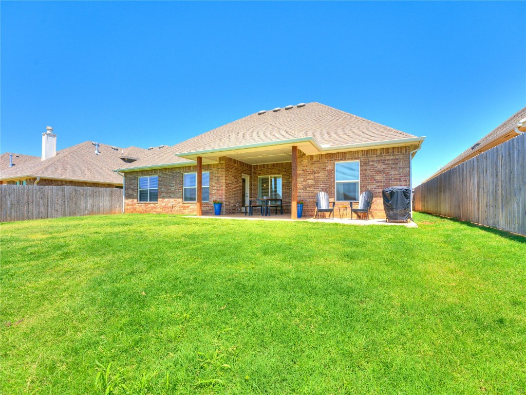 18725 Big Cedar Way, Edmond, OK 73012 rear view of property with a lawn and a patio area