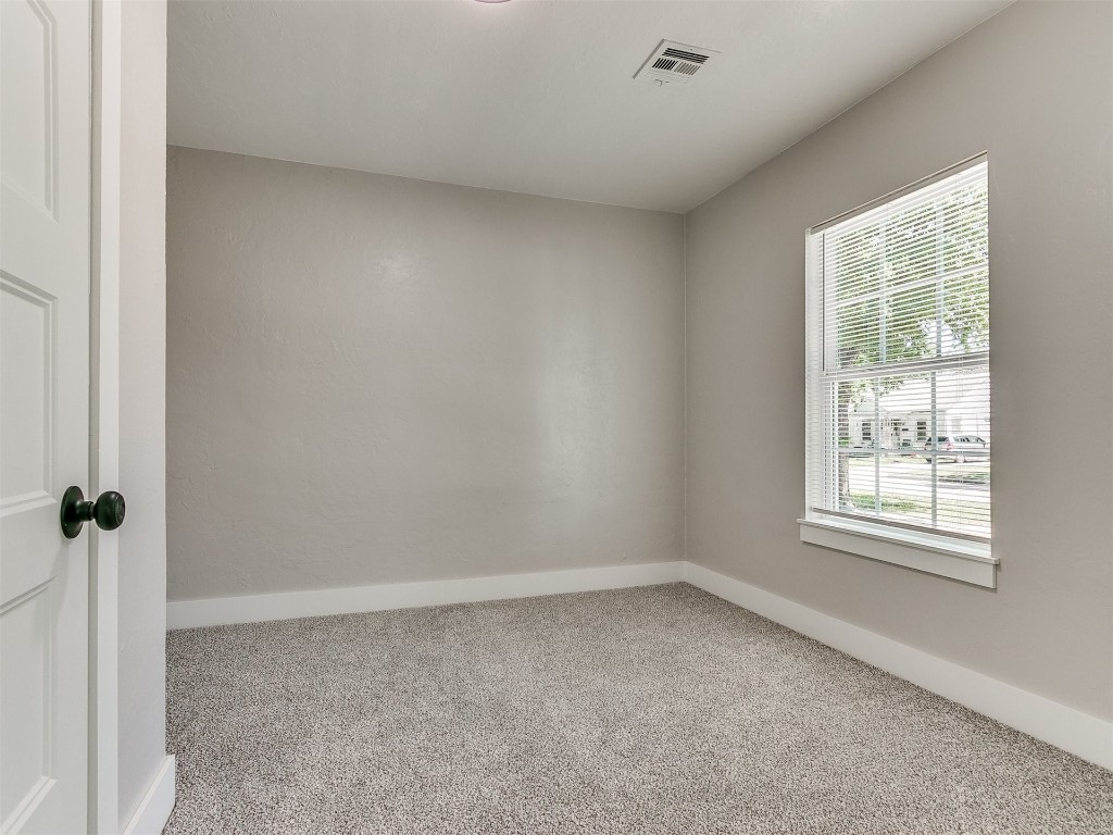 2213 NW 31 Street, #4056278939, Oklahoma City, OK 73112 unfurnished bedroom featuring connected bathroom and carpet flooring