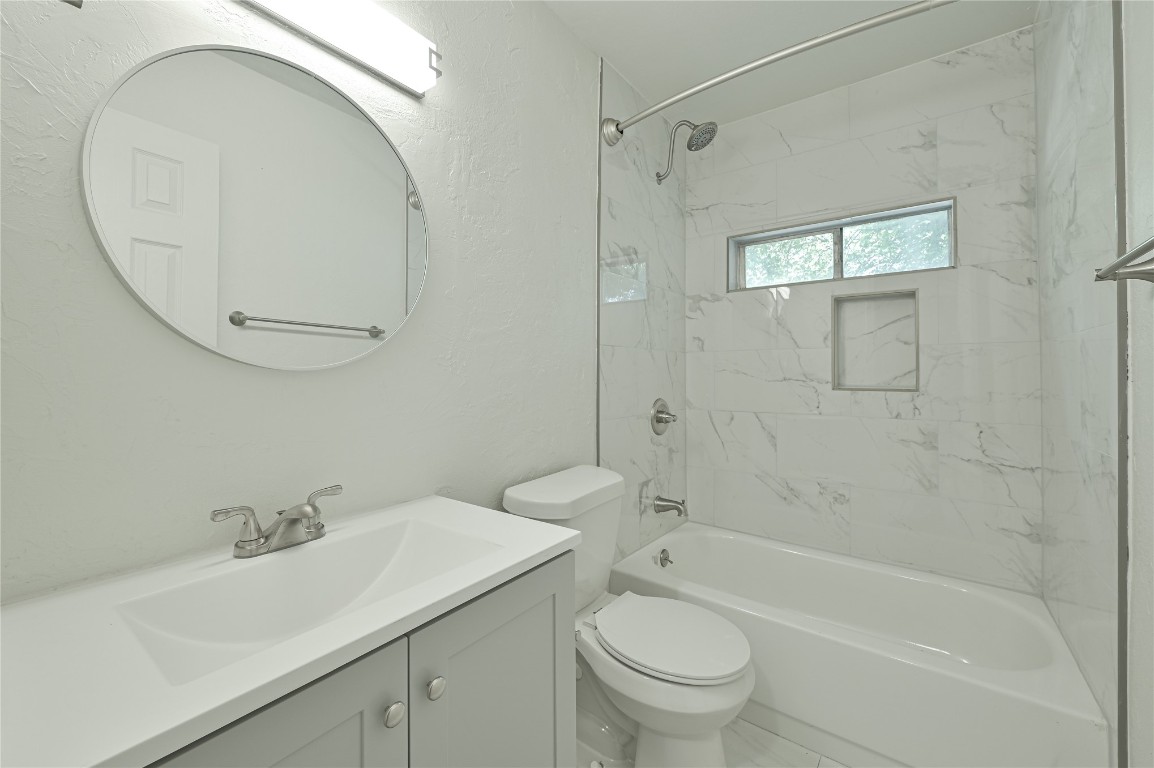 3013 SW 28th Street, Oklahoma City, OK 73108 full bathroom featuring tiled shower / bath combo, vanity, and toilet