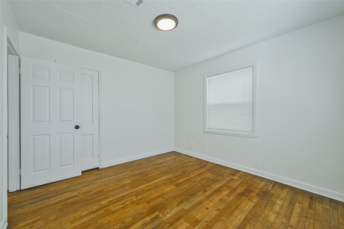 3013 SW 28th Street, Oklahoma City, OK 73108 empty room featuring hardwood / wood-style flooring and a textured ceiling