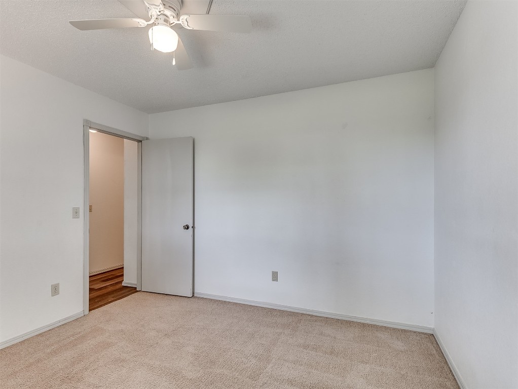 935 W Ridgehaven Way, Mustang, OK 73064 spare room with light colored carpet and ceiling fan