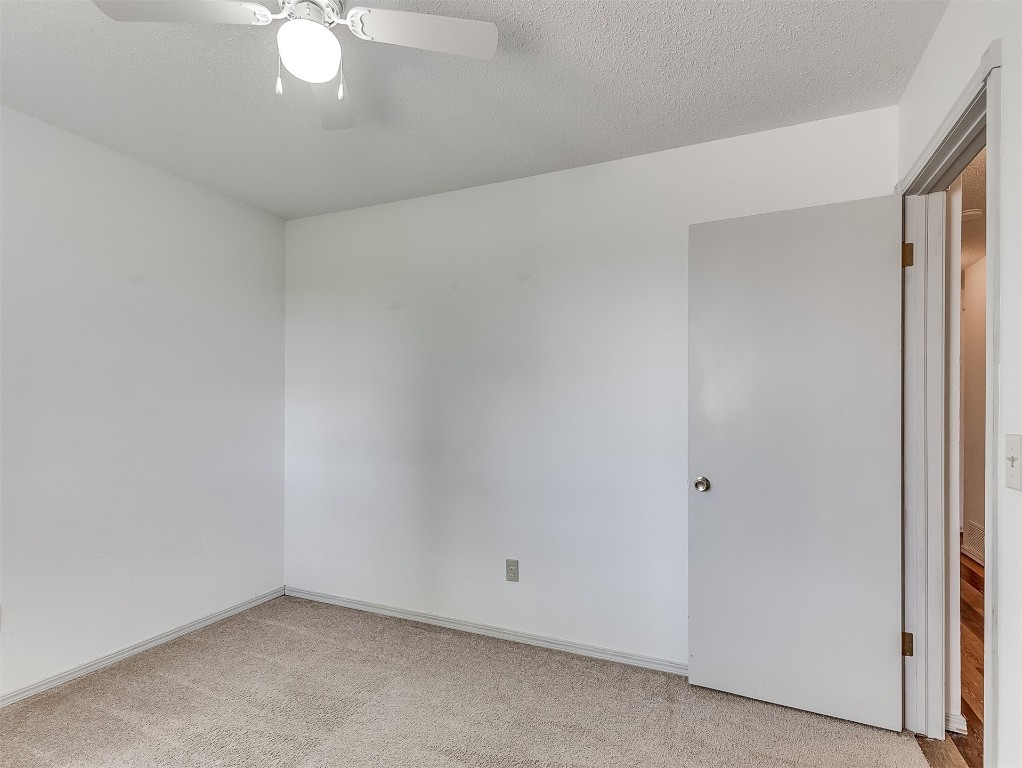 935 W Ridgehaven Way, Mustang, OK 73064 carpeted empty room with ceiling fan and a textured ceiling