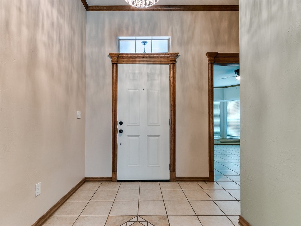 1400 NW 9th Street, Moore, OK 73170 foyer featuring crown molding, ceiling fan, and light tile floors