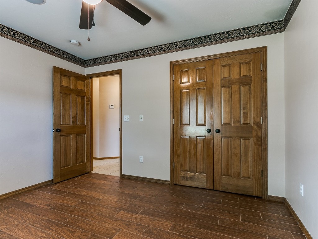 1400 NW 9th Street, Moore, OK 73170 unfurnished bedroom with a closet, ceiling fan, and dark hardwood / wood-style floors