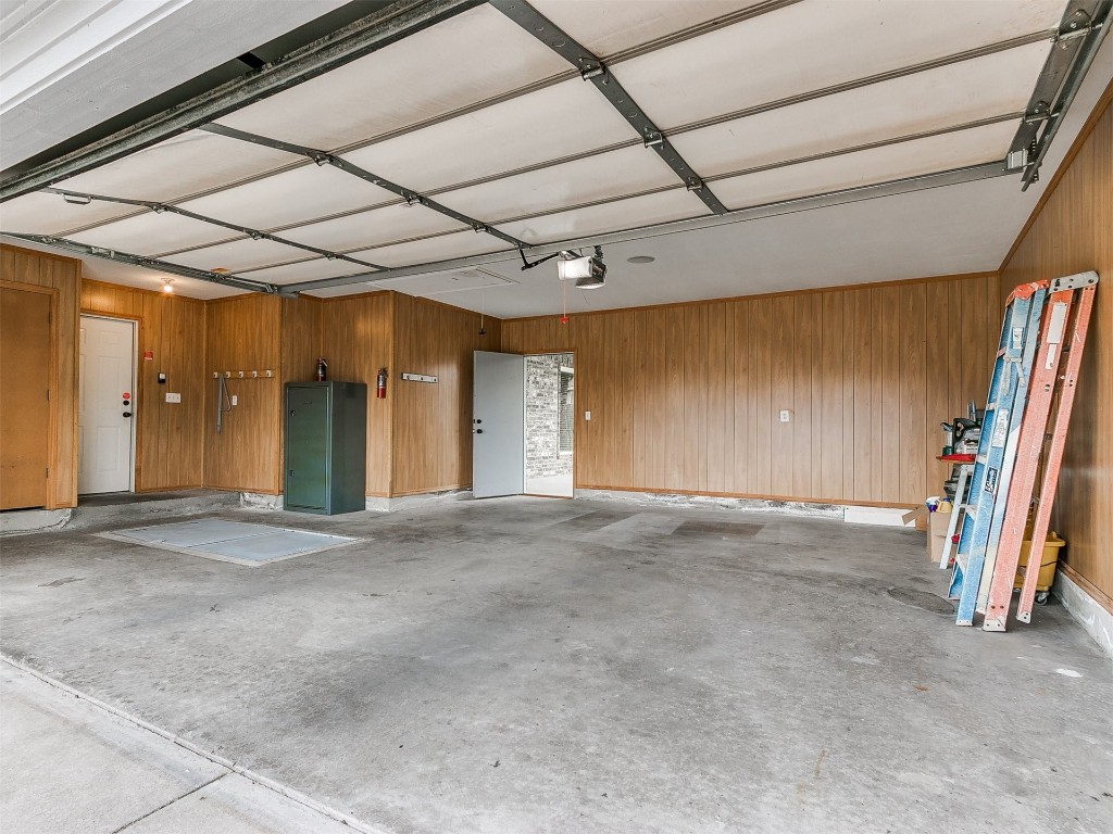 1400 NW 9th Street, Moore, OK 73170 garage featuring wood walls and a garage door opener