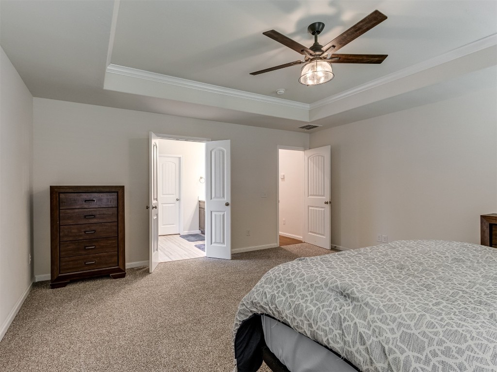 1107 SE 17th Terrace, Newcastle, OK 73065 carpeted bedroom with ceiling fan, a tray ceiling, and crown molding