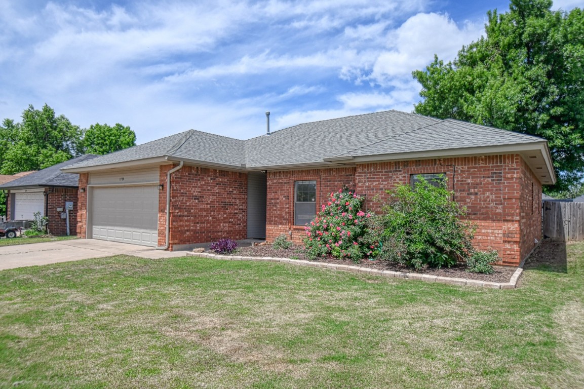 1725 Ryan Way, Edmond, OK 73003 ranch-style home with a garage and a front yard