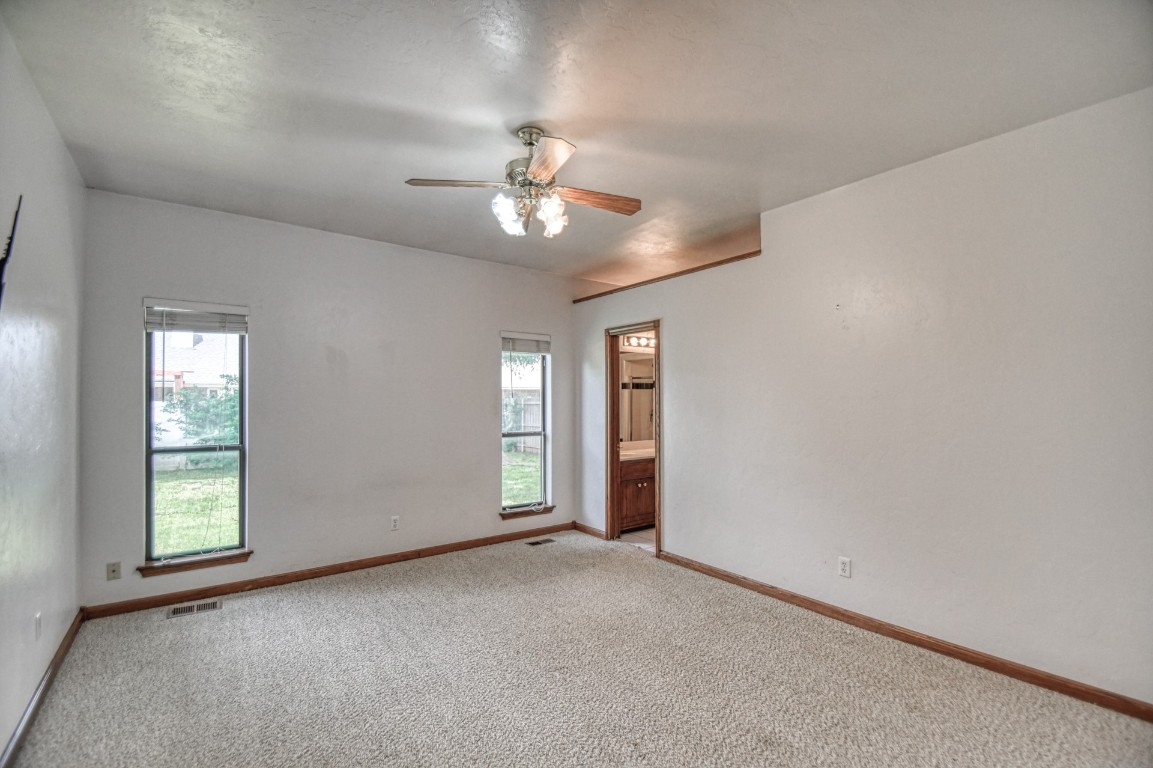 1725 Ryan Way, Edmond, OK 73003 carpeted empty room featuring ceiling fan and a healthy amount of sunlight