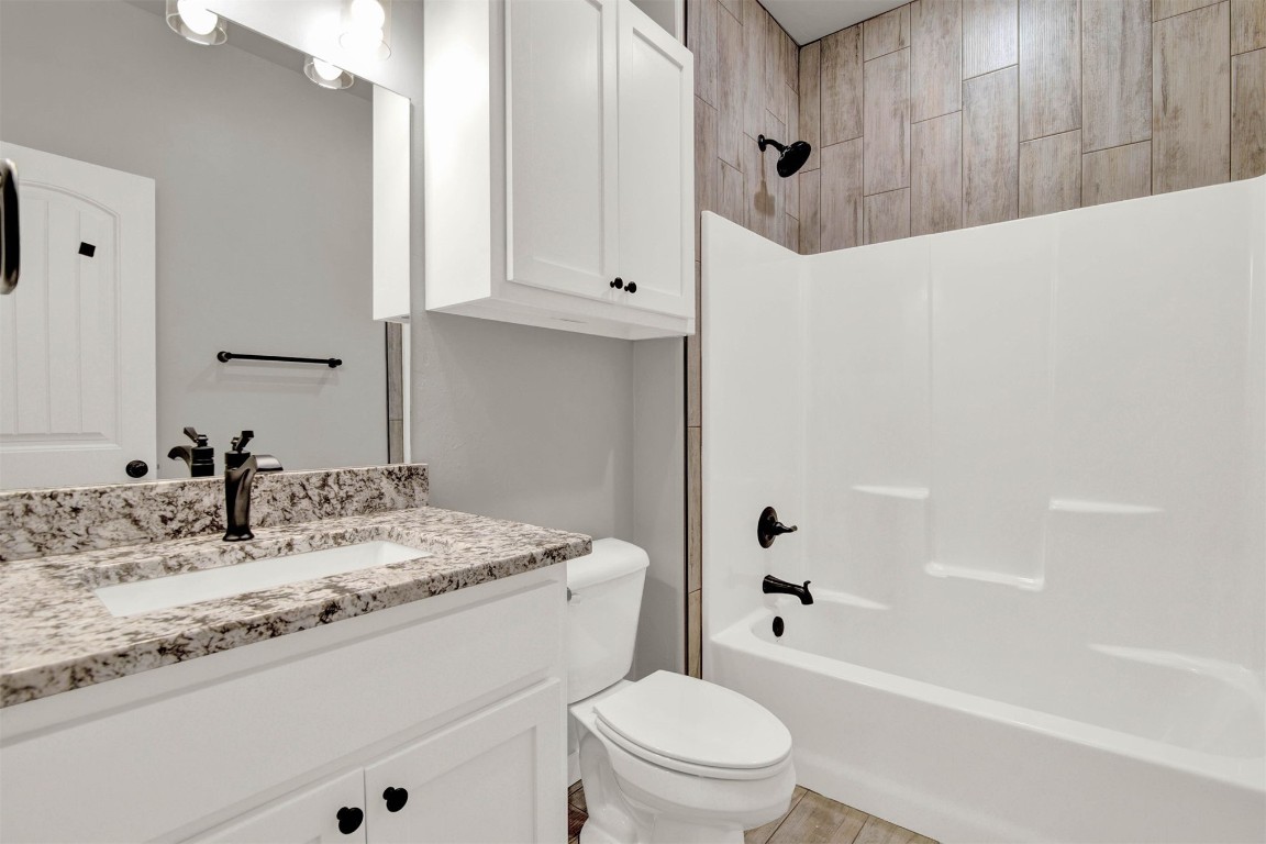 2105 Valley View, Weatherford, OK 73096 full bathroom featuring wood-type flooring, shower / bathing tub combination, toilet, and large vanity