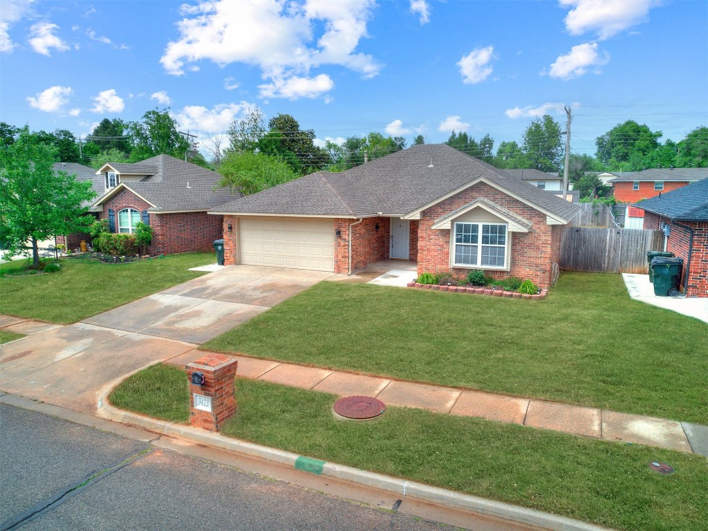 9413 Apple Drive, Midwest City, OK 73130 ranch-style home with a garage and a front lawn
