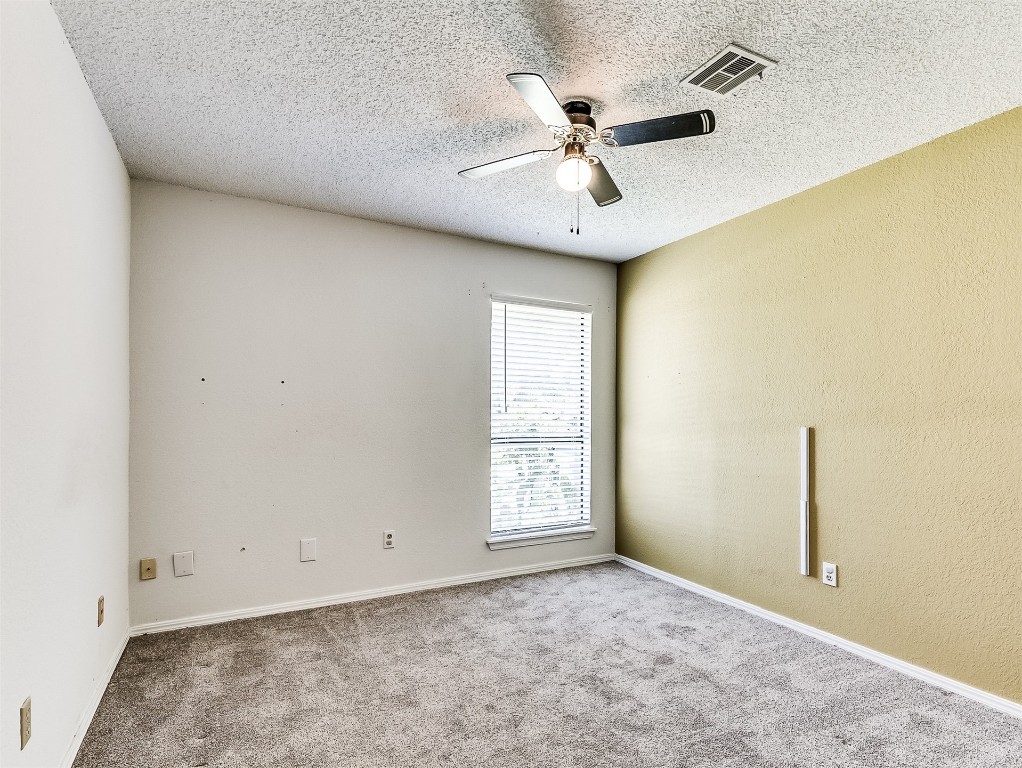 10525 Reiter Drive, Midwest City, OK 73130 spare room featuring a textured ceiling, ceiling fan, and carpet