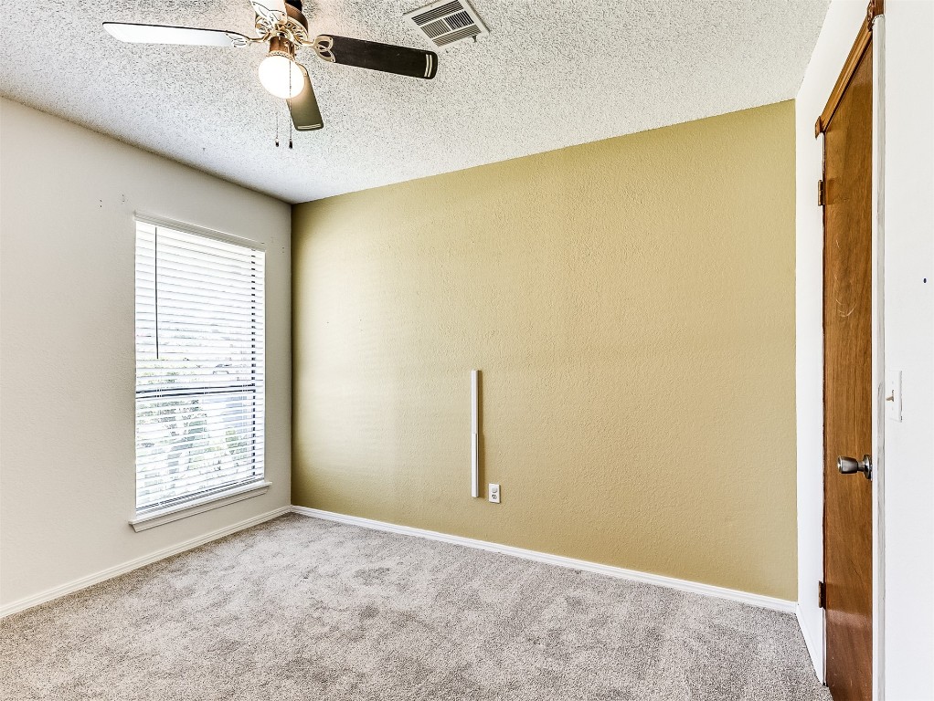 10525 Reiter Drive, Midwest City, OK 73130 spare room featuring a textured ceiling, ceiling fan, and carpet