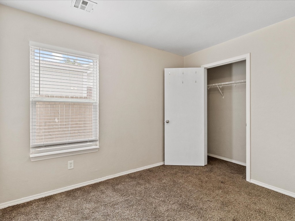 9708 SW 24th Terrace, Oklahoma City, OK 73128 unfurnished bedroom featuring a closet and dark carpet
