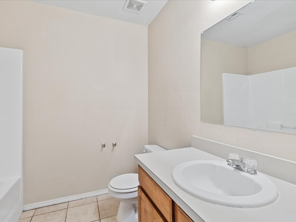 9708 SW 24th Terrace, Oklahoma City, OK 73128 full bathroom with tile flooring, washtub / shower combination, vanity, and toilet